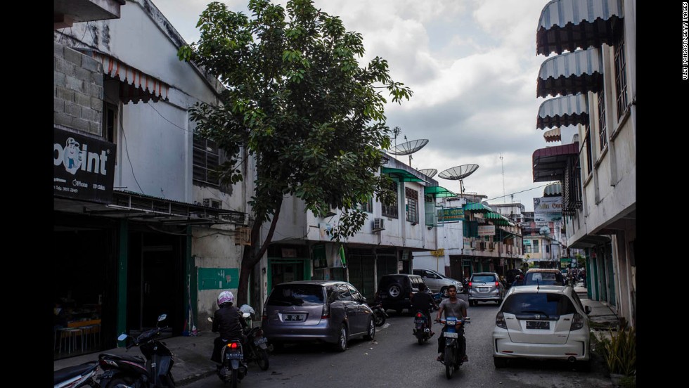 Ten years later, the debris has been cleared and people drive on Pembangunan Street. 