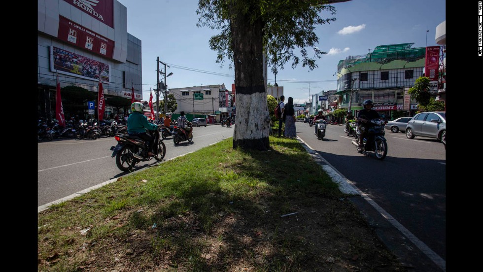 People drive along Panglima Polim Street 10 years later.