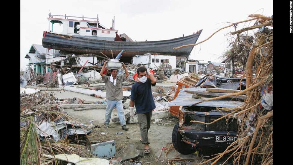 People walk among the debris of their ruined neighborhood on January 4, 2005, in Banda Aceh.