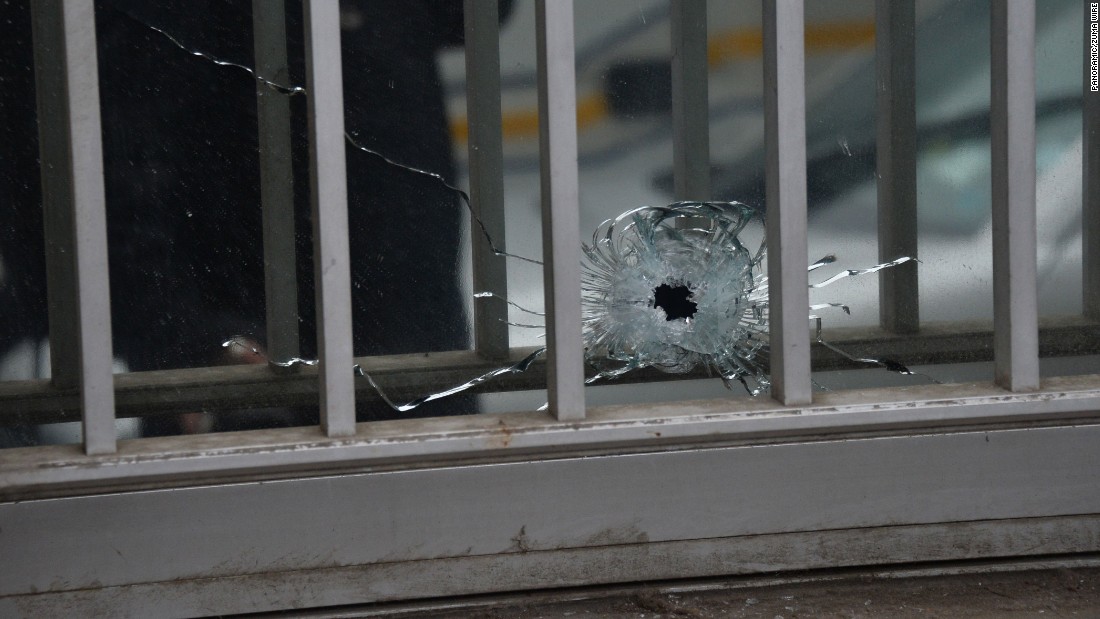 A bullet hole is seen in a window of the magazine&#39;s building.