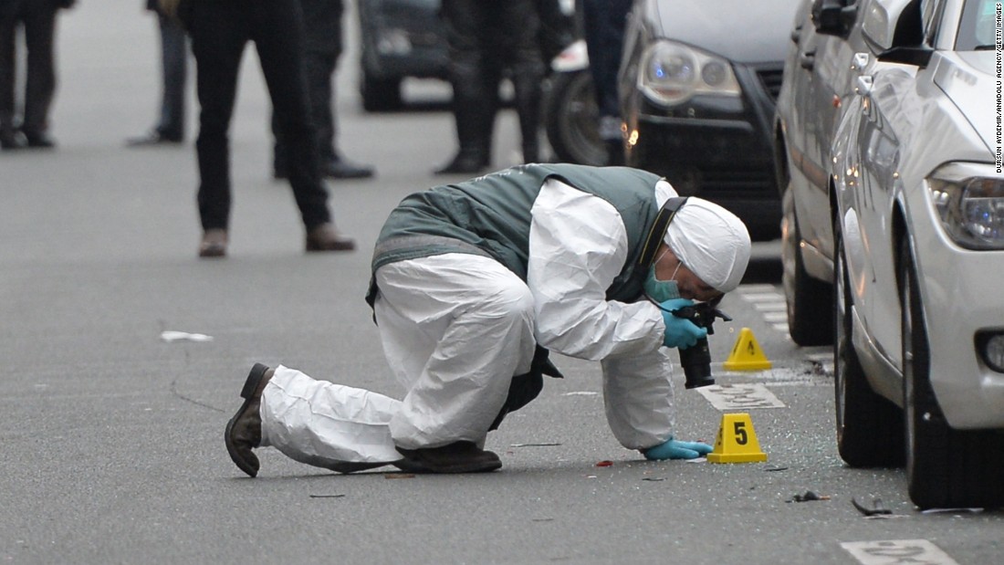 Police officers inspect evidence at the scene of the shooting.