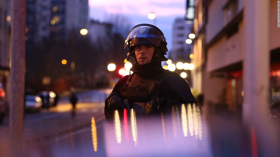 A police officer is seen at the scene of the standoff. Police union spokesman Pascal Disand said the hostage-taker, Amedy Coulibaly, demanded freedom for Cherif and Said Kouachi, the suspects in Wednesday&#39;s massacre at the Charlie Hebdo magazine office in Paris, who were simultaneously involved in a standoff wiith police northeast of Paris. Disand said the brothers and Coulibaly were part of the same jihadist groups.