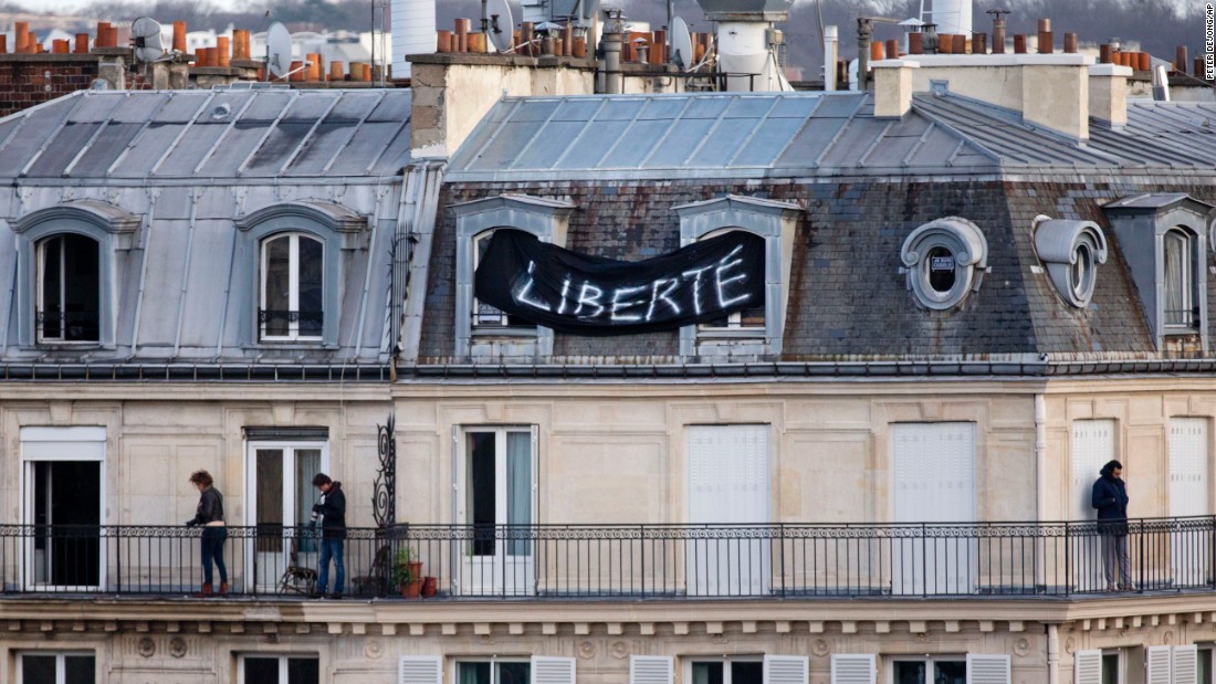 A banner attached to a house overlooking the Place de la Republique reads &quot;Freedom&quot; as thousands of people gather below.