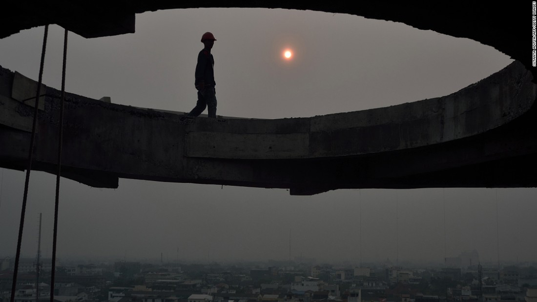 Construction workers labor against the backdrop of a hazy sun In Medan, Indonesia. The province declared a state of emergency when smogs worsened in 2013.