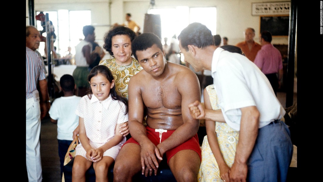 Ali sits with young fans in the gym while listening to his trainer, Angelo Dundee. 