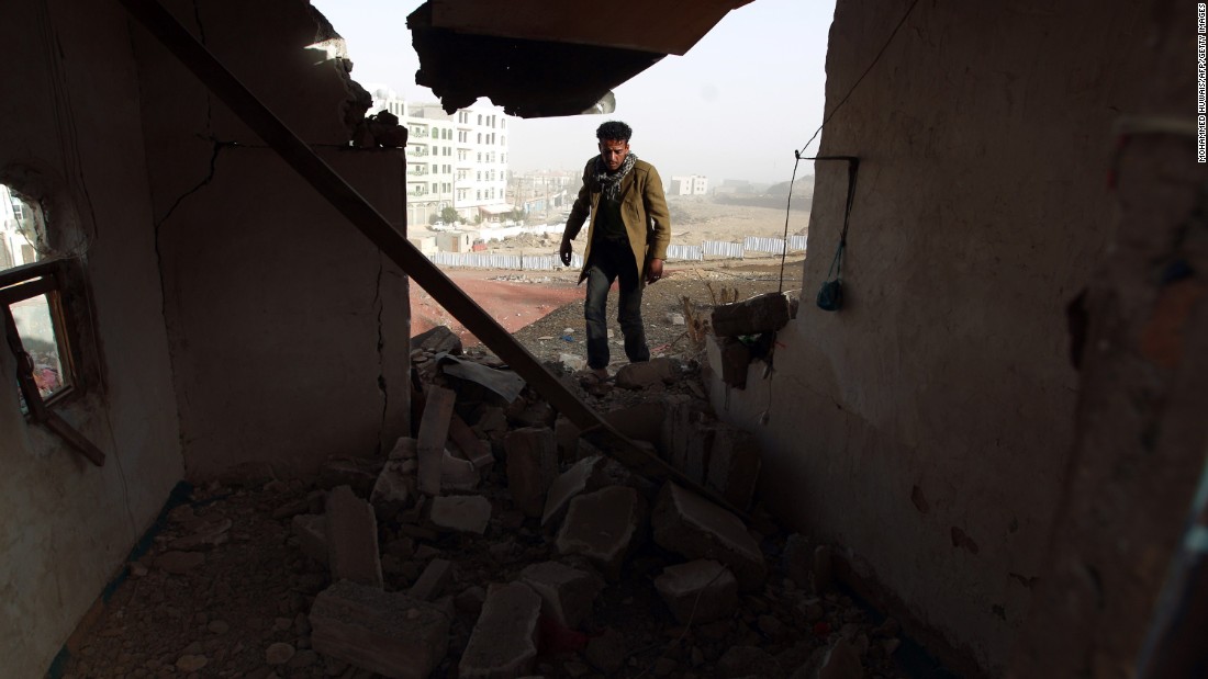 A man walks inside a heavily damaged house near the presidential palace on Tuesday, January 20.