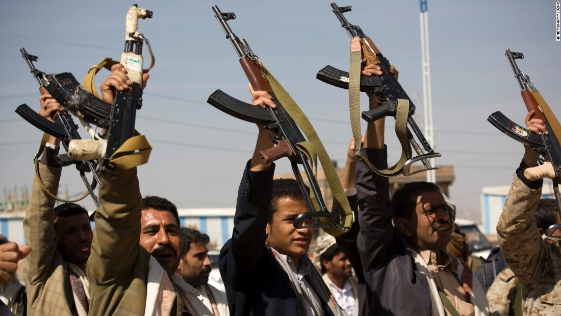 Houthi men raise their weapons during clashes near the presidential palace on Monday, January 19.