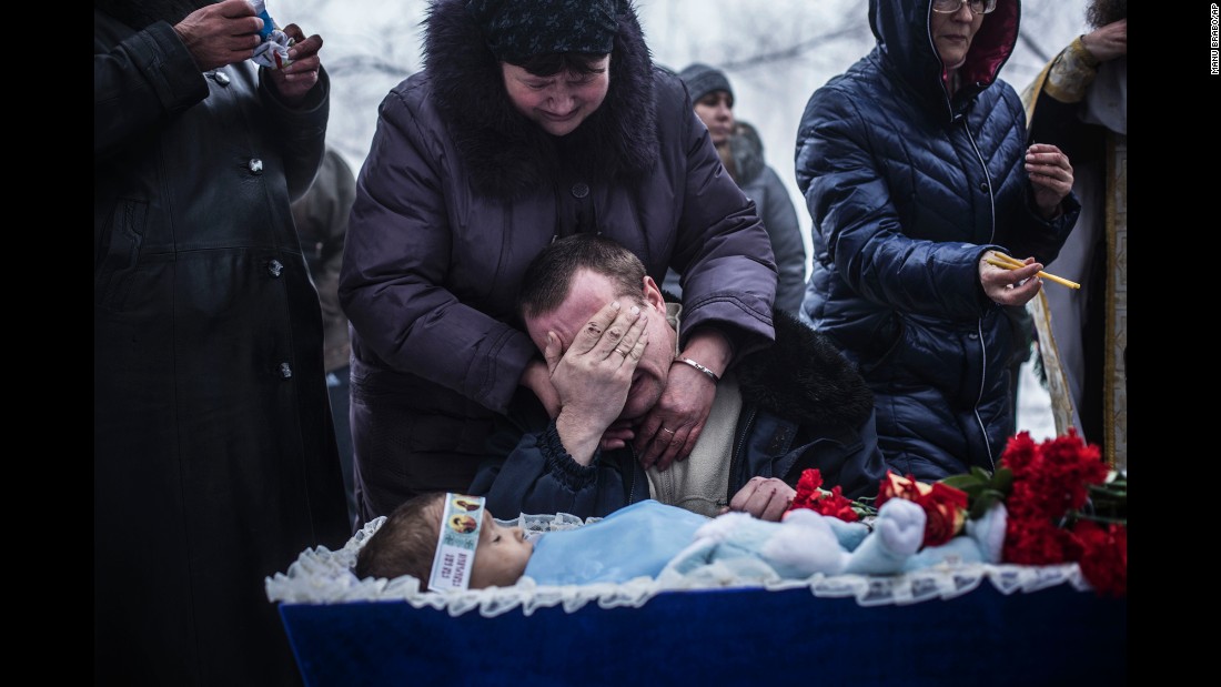 Vladimir Bovrichev cries next to the body of his 4-year-old son, Artiam, during Artiam&#39;s funeral on the outskirts of Donetsk on Tuesday, January 20. The boy was killed during a Ukrainian artillery strike.