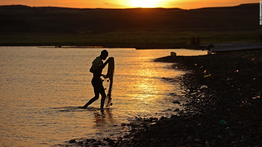 A fisherman from the El Molo tribe walks ashore as the sun rises over Komote, a village on the banks of Lake Turkana, Kenya, near the location of the new wind farm.