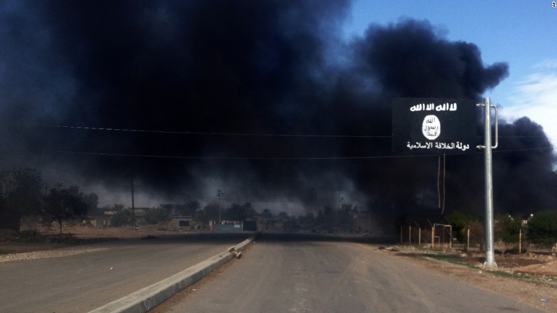 Smoke billows behind an ISIS sign during an Iraqi military operation to regain control of the town of Sadiyah, about 95 kilometers (60 miles) north of Baghdad, on Tuesday, November 25.