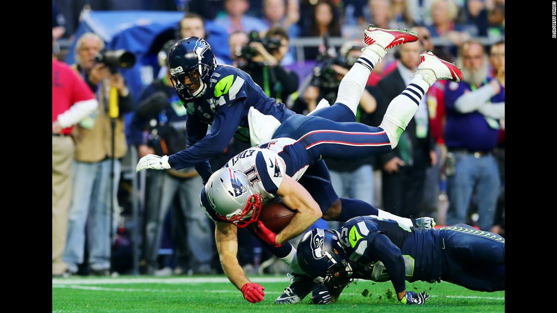 Edelman is tackled by two Seahawks during the first half.