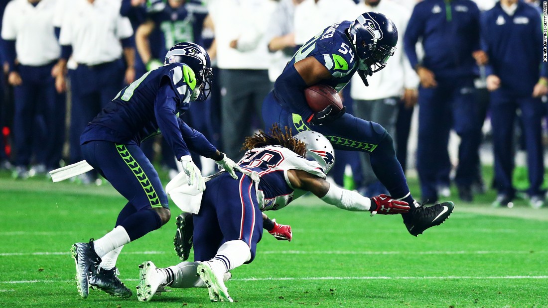 Seattle linebacker Bobby Wagner, right, runs the ball after intercepting Brady in the third quarter. The turnover set up Baldwin&#39;s touchdown drive.