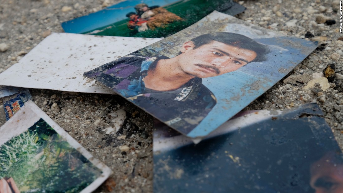 Photographs of civilians are seen on a street outside of a destroyed house on Saturday, January 31.