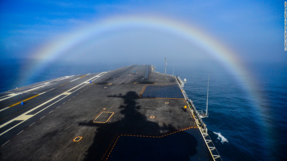 A rainbow forms over the bow of the Nimitz-class aircraft carrier USS John C. Stennis as the ship steams in the Pacific Ocean on February 3, 2015. 