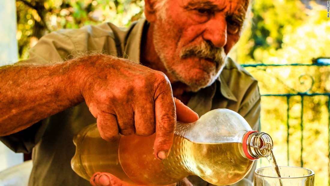 Alexandro Koufadakis, 84, pours a lunchtime glass of homemade wine.