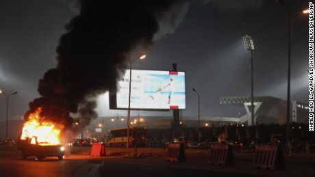 A pickup truck bursts into flames outside the stadium. 