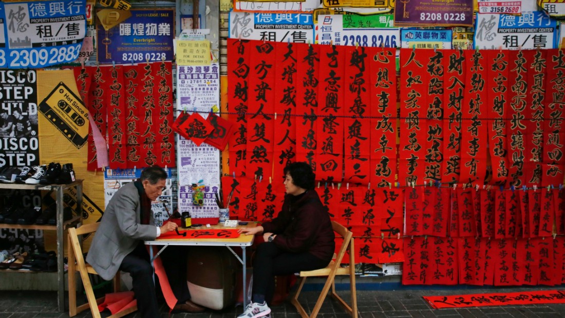 A calligrapher, left, writes auspicious characters on red paper to celebrate the  Lunar New Year in Hong Kong on Wednesday, February 4. 