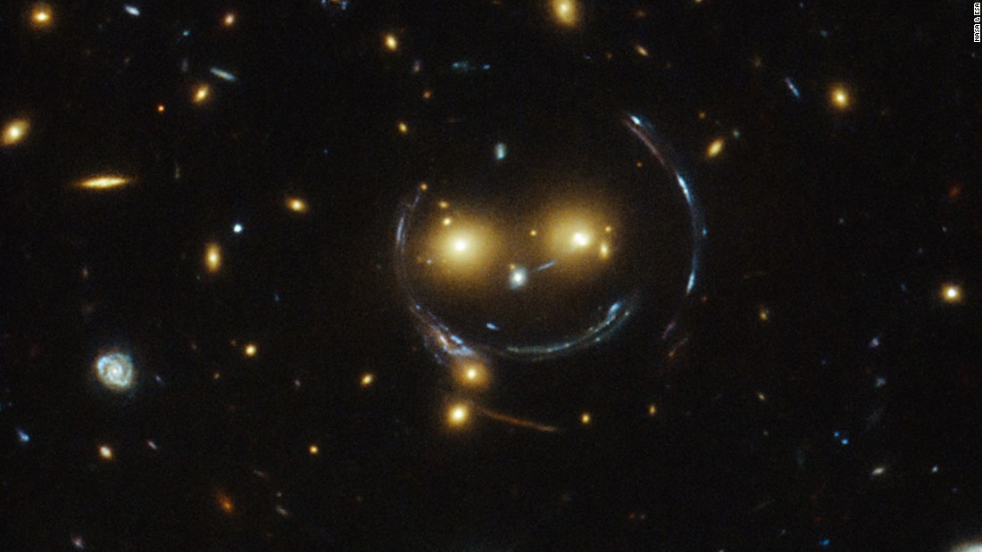A massive galaxy cluster known as SDSS J1038+4849 &lt;a href=&quot;http://www.cnn.com/2015/02/10/tech/space-smiley-face/index.html&quot;&gt;looks like a smiley face&lt;/a&gt; in an image captured by the Hubble Telescope. The two glowing eyes are actually two distant galaxies. And what of the smile and the round face? That&#39;s a result of what astronomers call &quot;strong gravitational lensing.&quot; That happens because the gravitational pull between the two galaxy clusters is so strong it distorts time and space around them.