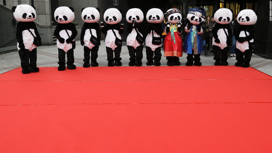 Workers wearing panda costumes wait for the start of a promotional event in front of a department store in Seoul, South Korea, on Tuesday, February 10.