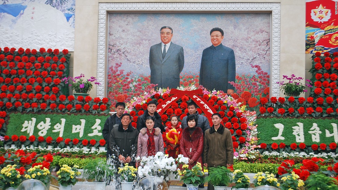Families frequently pose for photos with the portrait of regime founder Kim Il Sung (left) and his son, Kim Jong Il (right) at a flower show in Pyongyang celebrating Kim Jong Il&#39;s birthday. Commemorated in similar fashion, the birthday of Kim Il Sung is known as the Day of the Sun and falls on April 15.