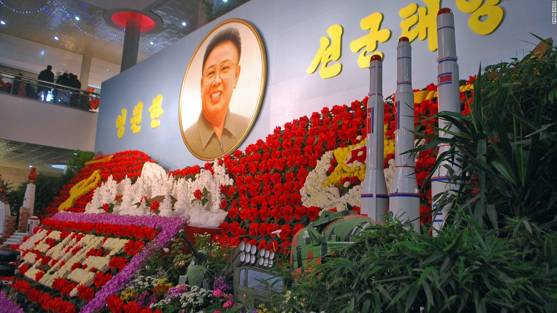 Yep, those are missiles in front of a portrait of Kim Jong Il surrounded by a display of Kimjongilias, the colorful flowers named after him.