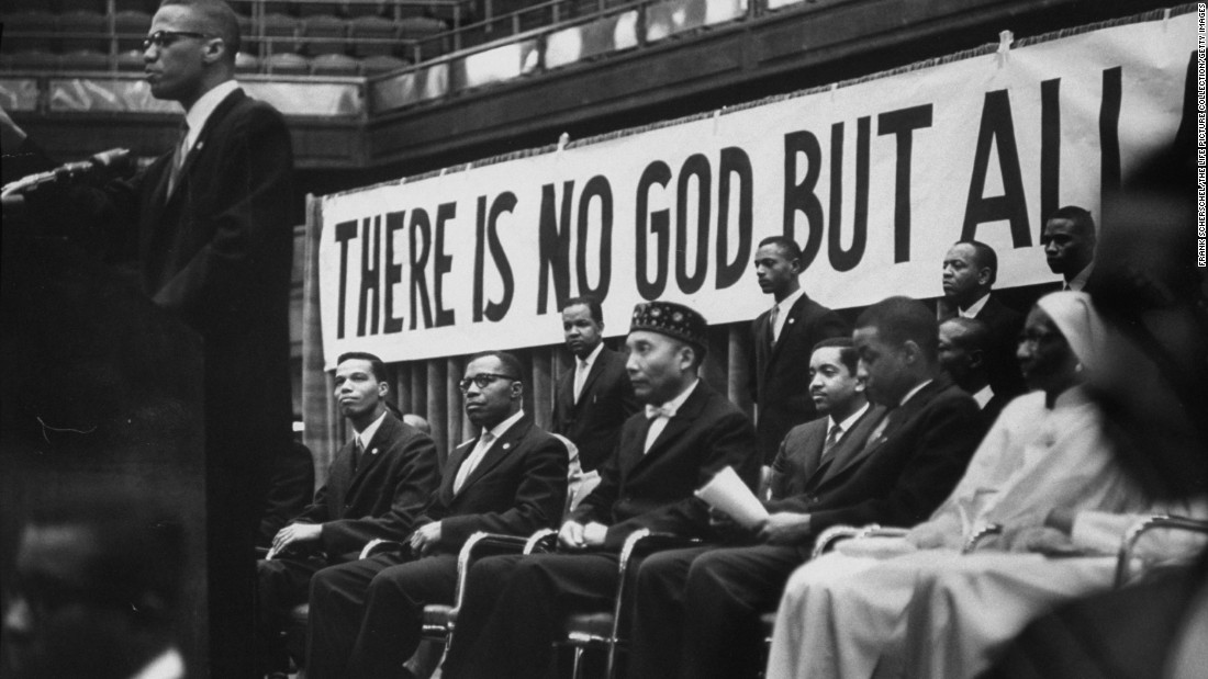 Nation of Islam leader Elijah Muhammad, seated in the hat, listens as Malcolm X speaks at a Nation of Islam convention in Chicago in February 1961. It was Malcolm X who bestowed the title &quot;Honorable&quot; to Muhammad. &lt;br /&gt;