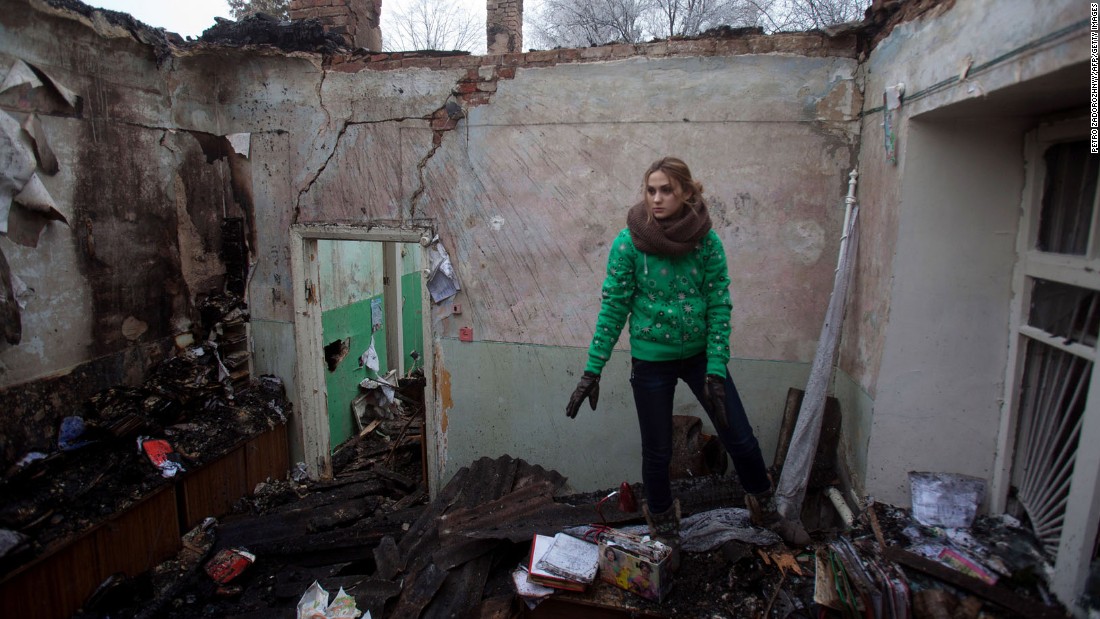 A woman salvages items February 15 from the rubble of a destroyed clinic where she had worked in Opytne, Ukraine.