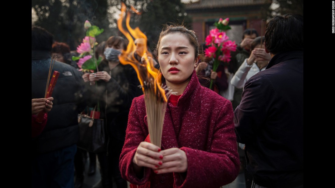 A woman holds incense at a Beijing temple February 19.