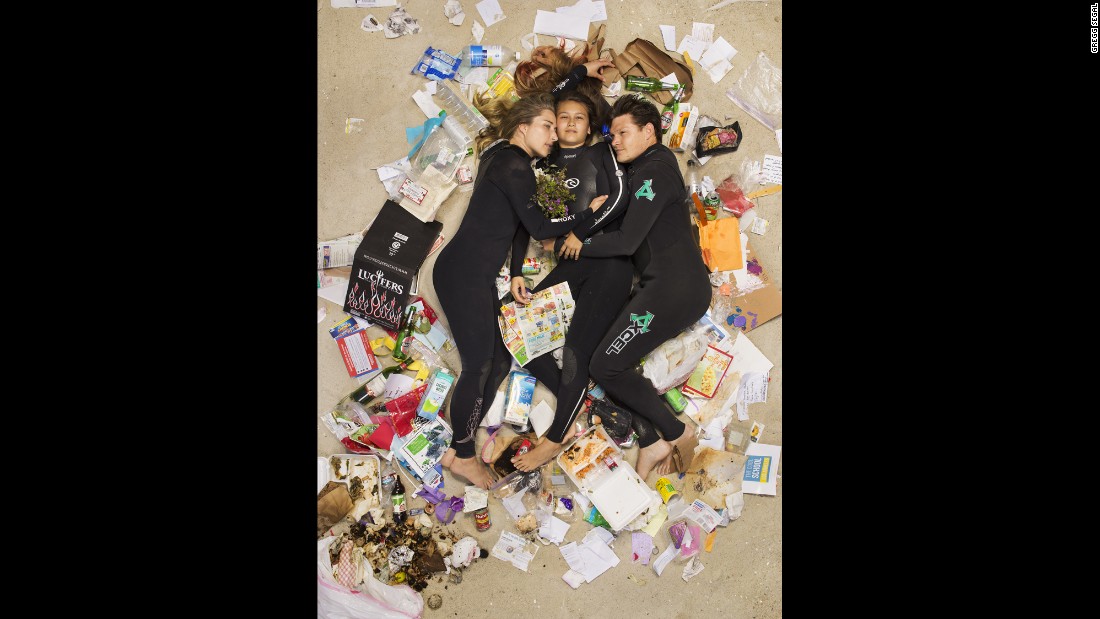 Susan, Curtis and Brittany cuddled up on the beach in wetsuits in their &quot;7 Days of Garbage&quot; shoot.