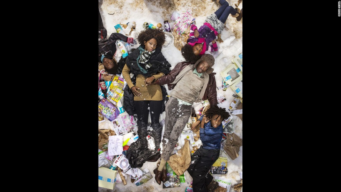 The Munroe family lies down in a snowy setting with a week of their trash.