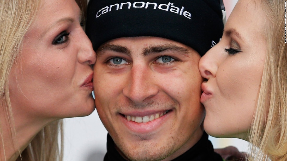 Cyclist Peter Sagan, who was the inspiration for the controversial poster, is kissed by two podium girls after winning last year&#39;s E3 Harelbeke race in Belgium.  