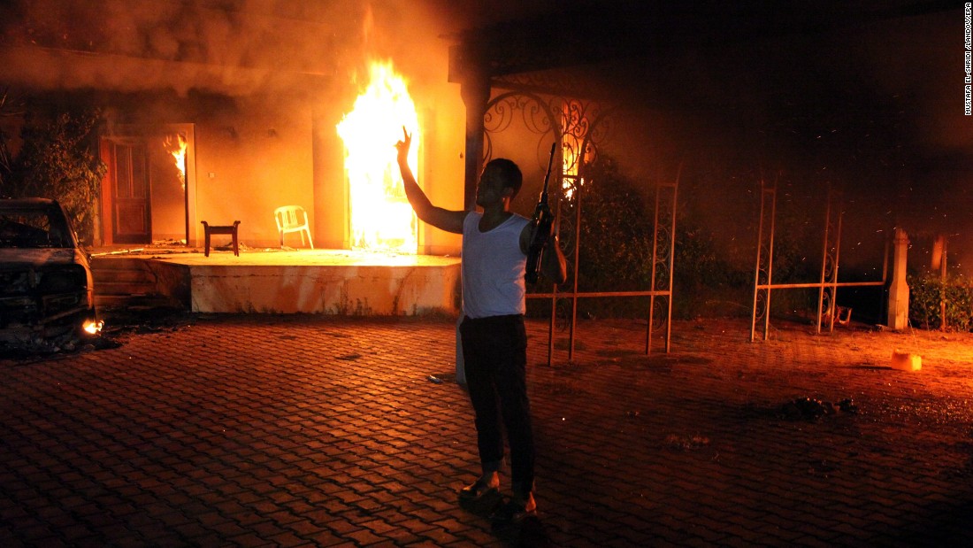 An armed man stands next to buildings set on fire at the U.S. consulate in Benghazi, Libya, on September 11, 2012. U.S. Ambassador J. Christopher Stevens and three other U.S. nationals were killed in the attack.