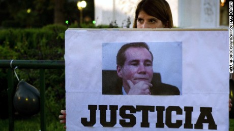A woman holds a sign reading "Justice" during a demo at Mayo square, in Buenos Aires on January 26, 2015, demanding justice in the death of Argentine public prosecutor Alberto Nisman --who was found dead in his home on January 18-- just hours before a congressional hearing to allegedly present evidence against President Cristina Fernandez de Kirchner of shielding Iranian officials implicated in a bomb attack on a Jewish community center in 1994 that left 85 dead. President Cristina Fernandez just announced during a national simultaneous broadcast she will disband Argentina's intelligence service "and create a Federal Intelligence Agency" with a leadership chosen by the president but subject to Senate approval"