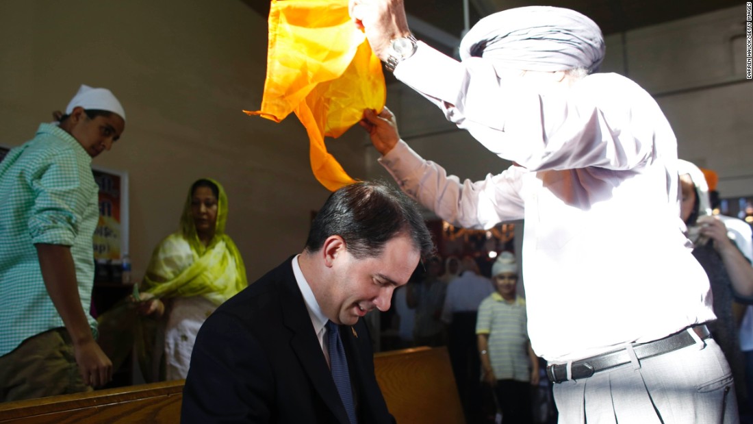 Walker has a scarf put on his head during a special service at the Sikh Religious Society of Wisconsin for the victims of the shooting at the Sikh Temple of Wisconsin the previous day, on August 6, 2012, in Brookfield, Wisconsin.