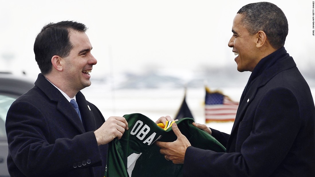 President Obama receives a Green Bay Packers NFL football team jersey with &#39;Obama #1&#39; written on it from Walker (left) at Austin Straubel International Airport in Green Bay, Wisconsin, on January 26, 2011.