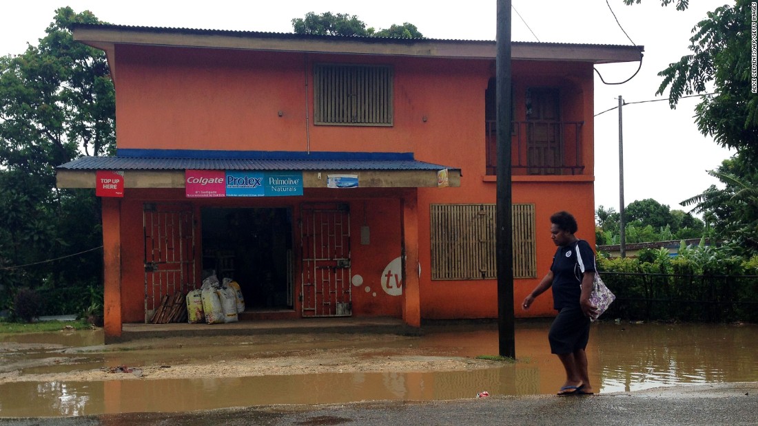 A person walks past flooding near Port Vila on March 13.