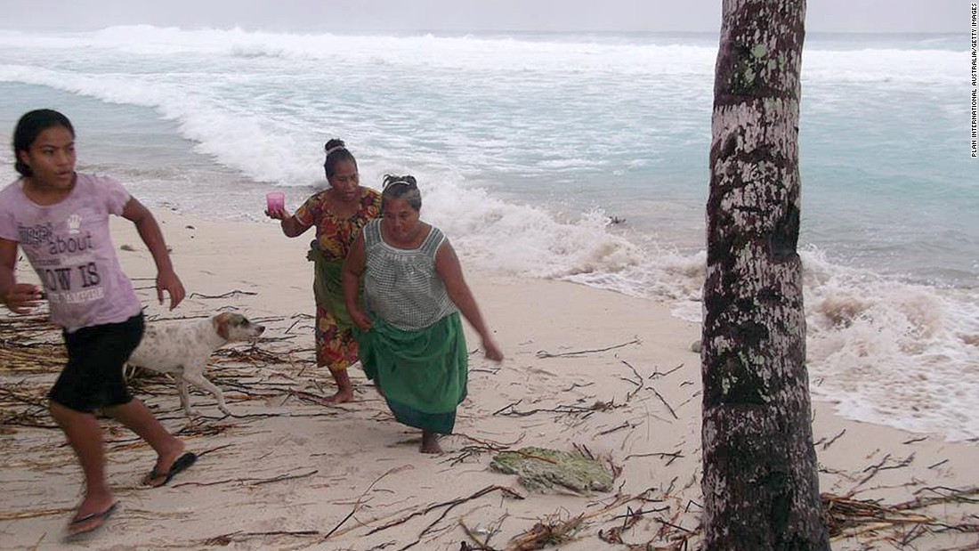 People move away from the beach March 13 on the island of Kiribati. 