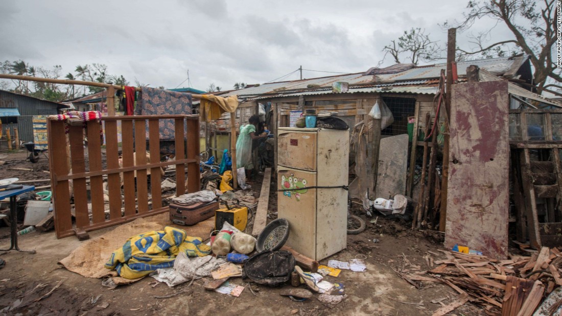 A resident stands in her badly damaged home outside Port Vila on March 15. 