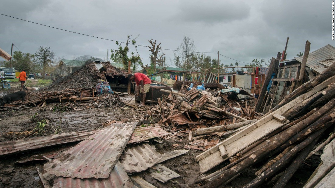 Residents work amid the debris left by the cyclone outside Port Vila on March 15. 