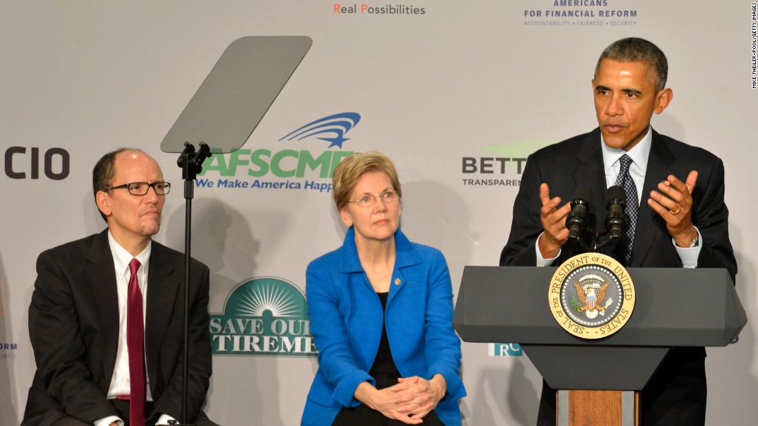 President Barack Obama (right) speaks as Warren and Labor Secretary Tom Perez listen at an AARP conference, February 23, 2015 in Washington, D.C. 