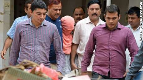 Indian policemen escort the juvenile (C, in pink hood), accused in the December 2012 gang-rape of a student, following his guilty verdict at a court in New Delhi on August 31, 2013. An Indian court found a teenager guilty August 31 over the fatal gang-rape of a student in New Delhi, a crime that sparked revulsion and angry protests in the country, an official said. AFP PHOTO/Prakash SINGH    