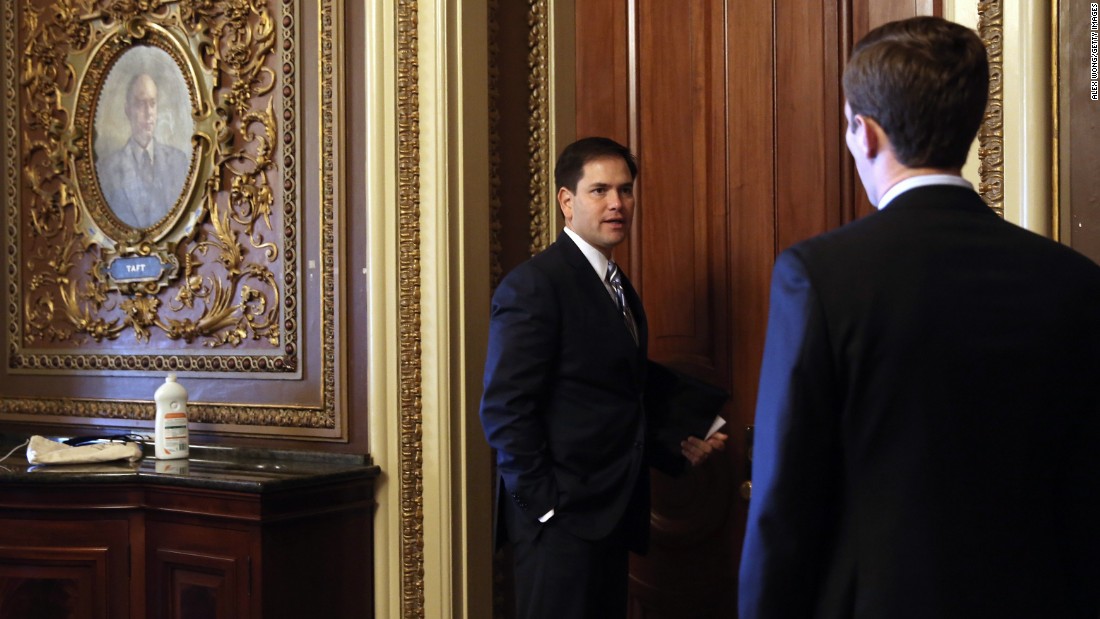 Rubio speaks to an aide on Capitol Hill as he arrives for the weekly Senate Republican Policy Committee luncheon in September 2013.