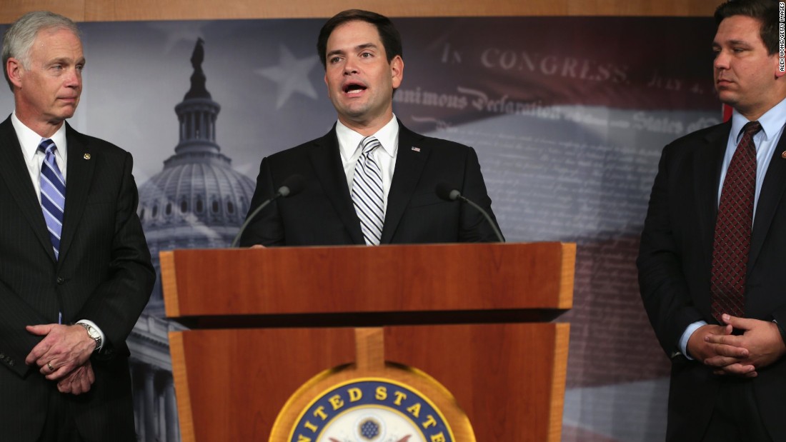 Rubio, center, speaks to members of the media as Sen. Ron Johnson, left, and Rep. Ron DeSantis listen during a news conference on Capitol Hill in October 2013.