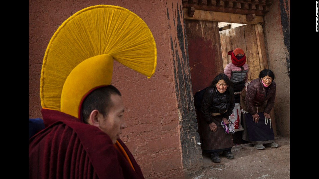 Devotees bow to a passing monk on his way to take part in a special prayer during the Monlam rituals on March 5, 2015. 