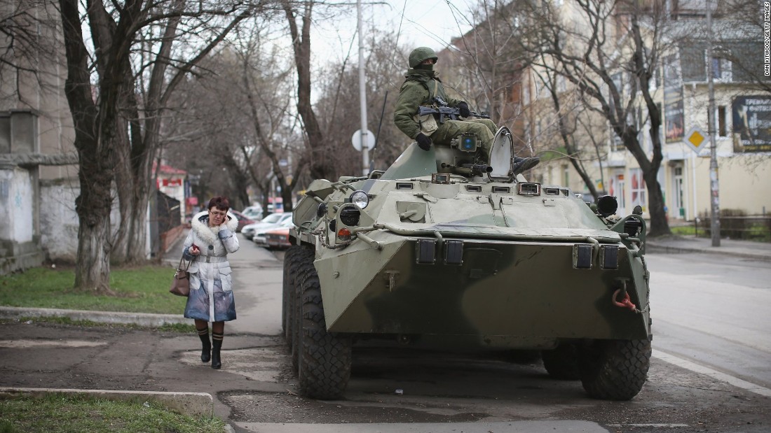  A woman walks past a Russian military personnel carrier outside a Ukrainian military base on March 18, 2014 in Simferopol, Ukraine. Voters on the autonomous Ukrainian peninsular of Crimea voted overwhelmingly to secede from their country and join Russia. 