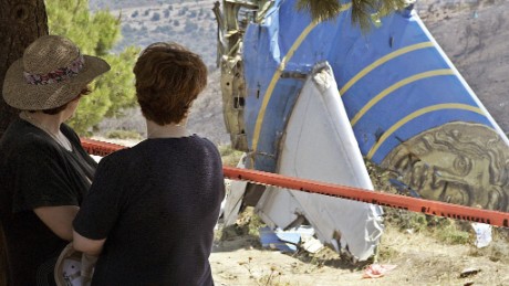 Women look at the debris of the Cypriot Helios airliner which crashed August 13, 2005 at Grammmatiko hills near Athens.