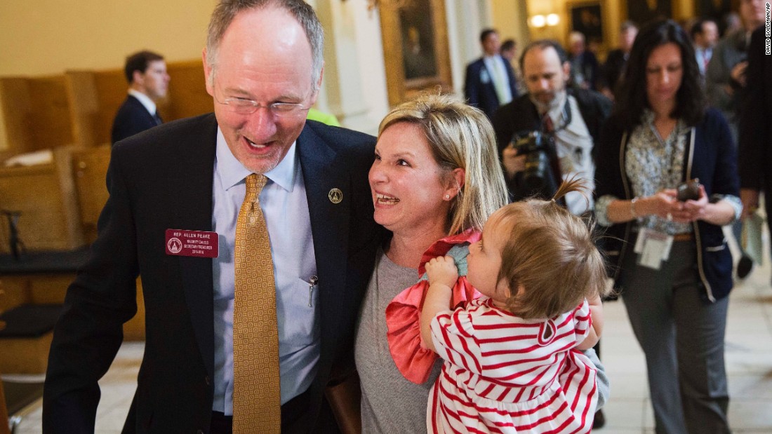 Georgia Rep. Allen Peake celebrates with Kristi Baggarly, holding her daughter Kimber, after the state Senate approved Peake&#39;s medical marijuana bill March 24, 2015 in Atlanta. The bill will legalize possession of cannabis oil for treatment of certain medical conditions, such as the seizures suffered by Baggarly&#39;s daughter Kendle.