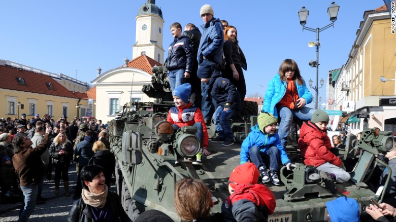 People surround a group of U.S. Army armored vehicles from the 3rd Squadron, 2nd Cavalry Regiment, on March 24 in Bialystok. The convoy started in Estonia and passed through Latvia and Lithuania before entering Poland on its way to a base in Germany.