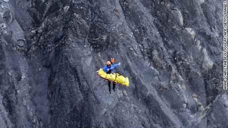 A rescue worker is lifted by helicopter from the crash site in the French Alps on March 26.