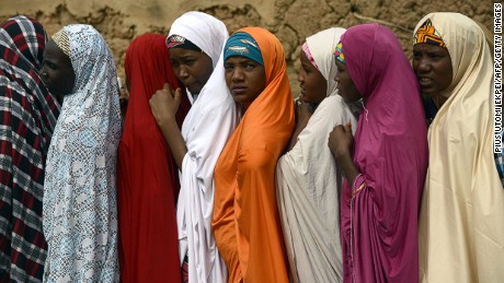 Women in khimars wait in line to cast their votes at a polling staion in Daura, Katsina State, northern Nigeria during presidential elections.